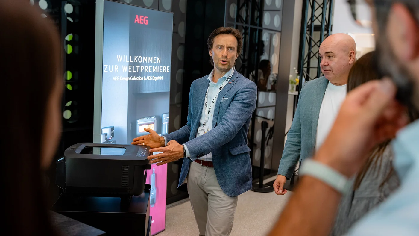 Презентація новинок AEG на стенді: представник бренду показує прилад відвідувачам