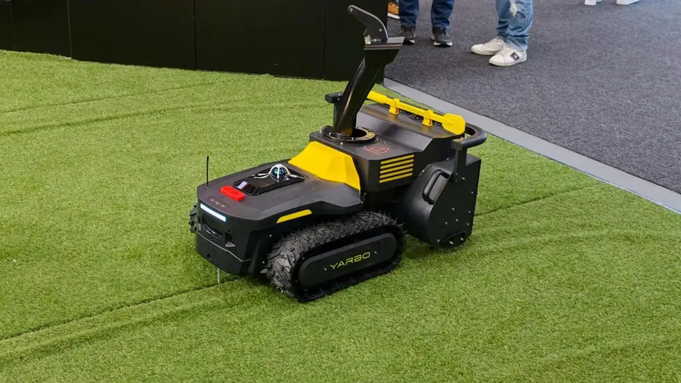 Модульний робот Yarbo M Series зі снігоприбиральним модулем на штучному газоні стенда Yarbo