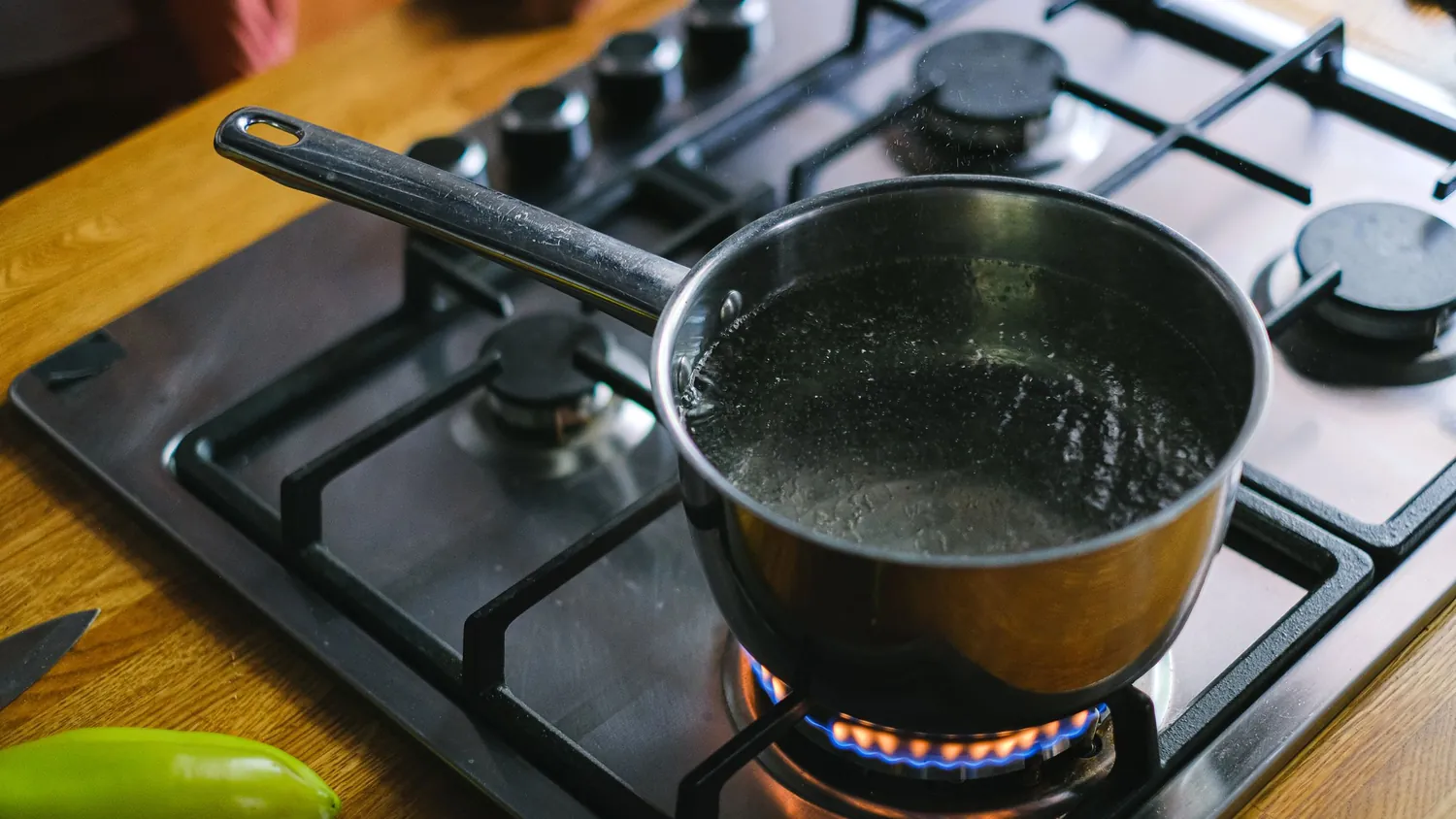 Каструля з гарячою водою на газовій плиті без бурхливого кипіння