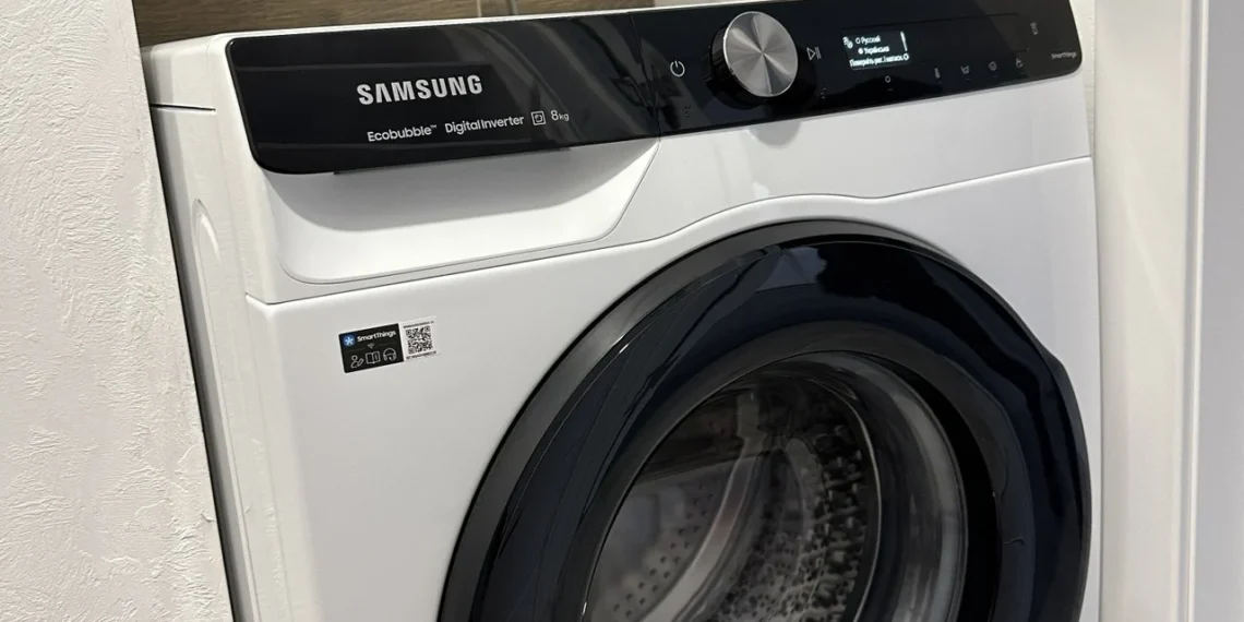 Підключена пральна машина Samsung у ніші ванної під час першого циклу, у барабані вода