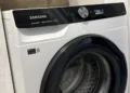 Підключена пральна машина Samsung у ніші ванної під час першого циклу, у барабані вода